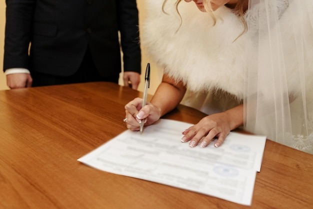 happy gorgeous bride and stylish groom signing official document wedding register emotional moment ceremony